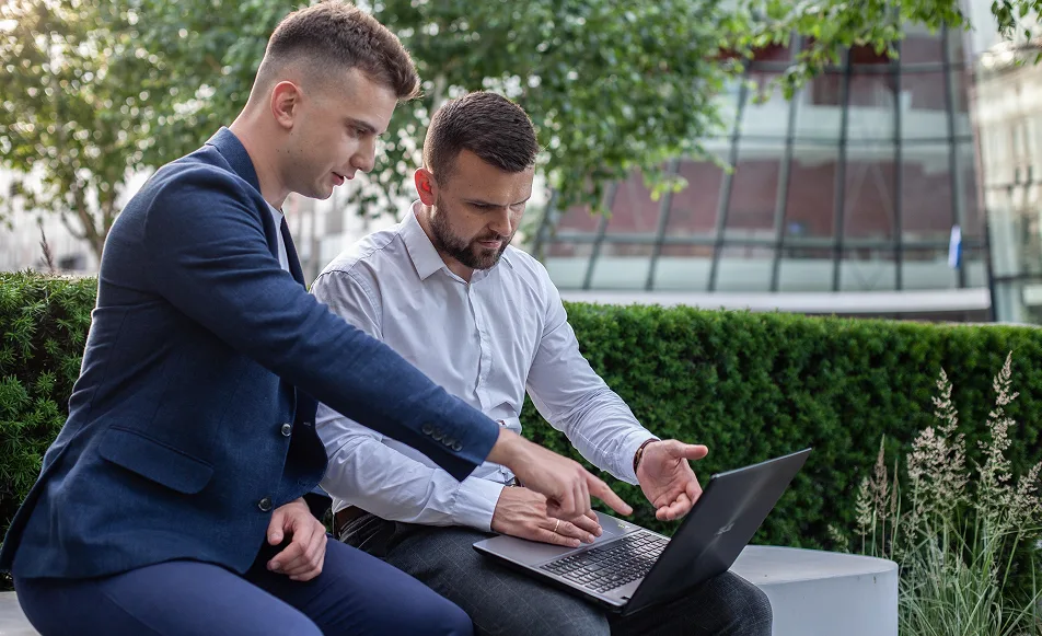 Filip i Jakub omawiają działania Lead Lever przy laptopie